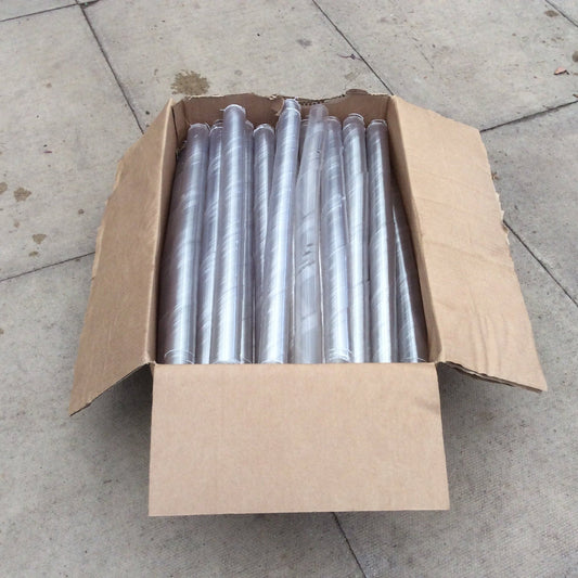An open brown cardboard box containing multiple clear plastic cylindrical sleeves or tubes, photographed on a concrete floor.